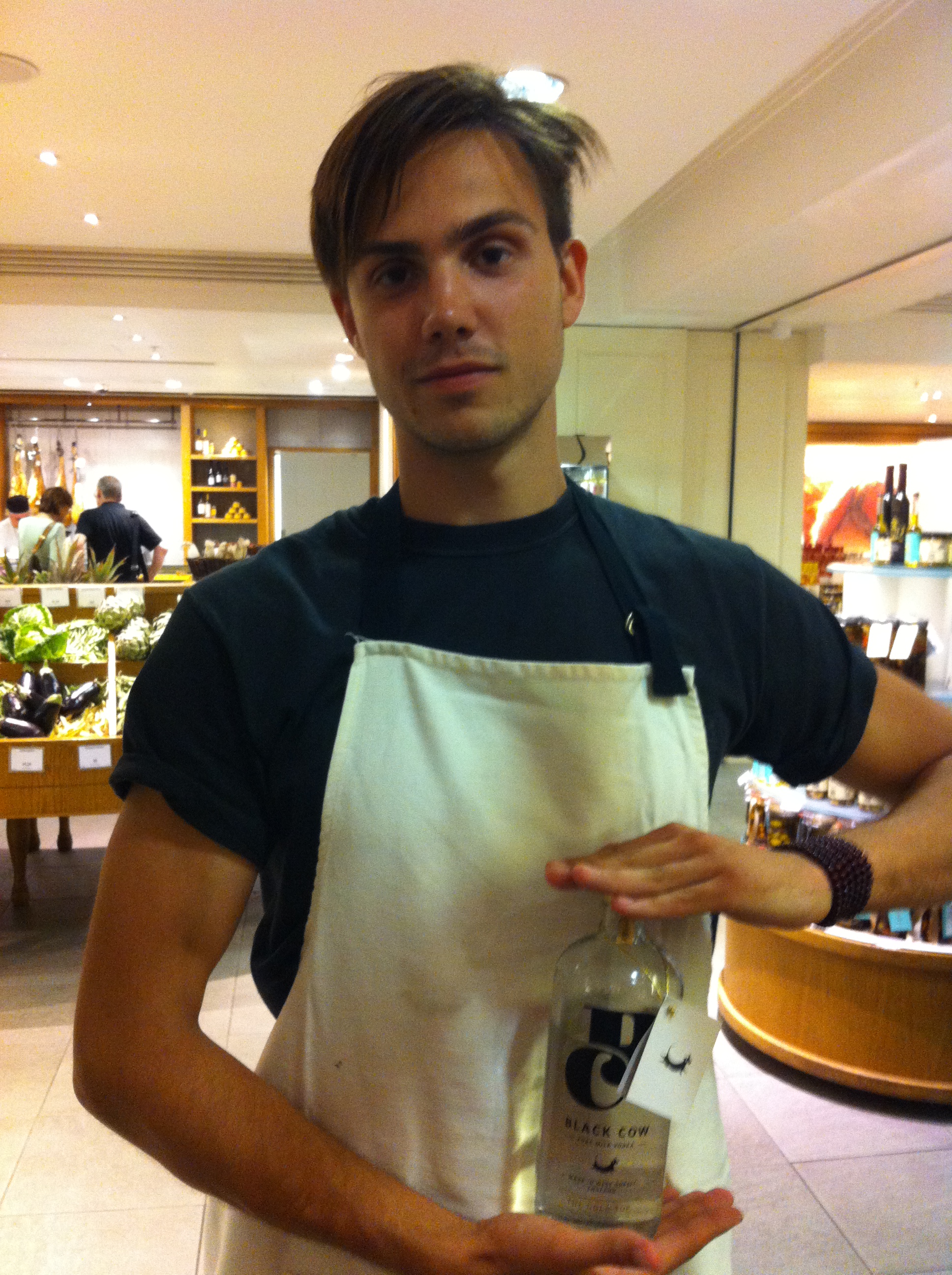 a Young man holding a vodka made out of milk