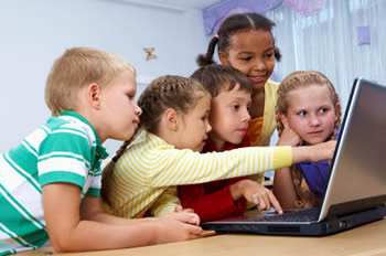 a bunch of kids sitting at a computer