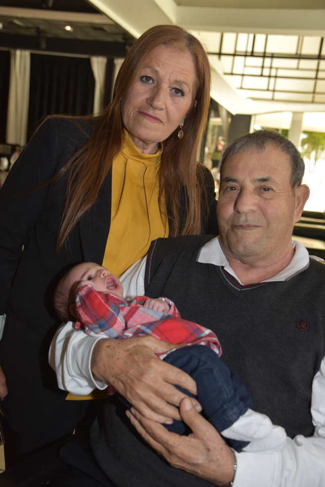 סבא וסבתא מצולמים בתמונה כשסבא מחזיק את נטע.