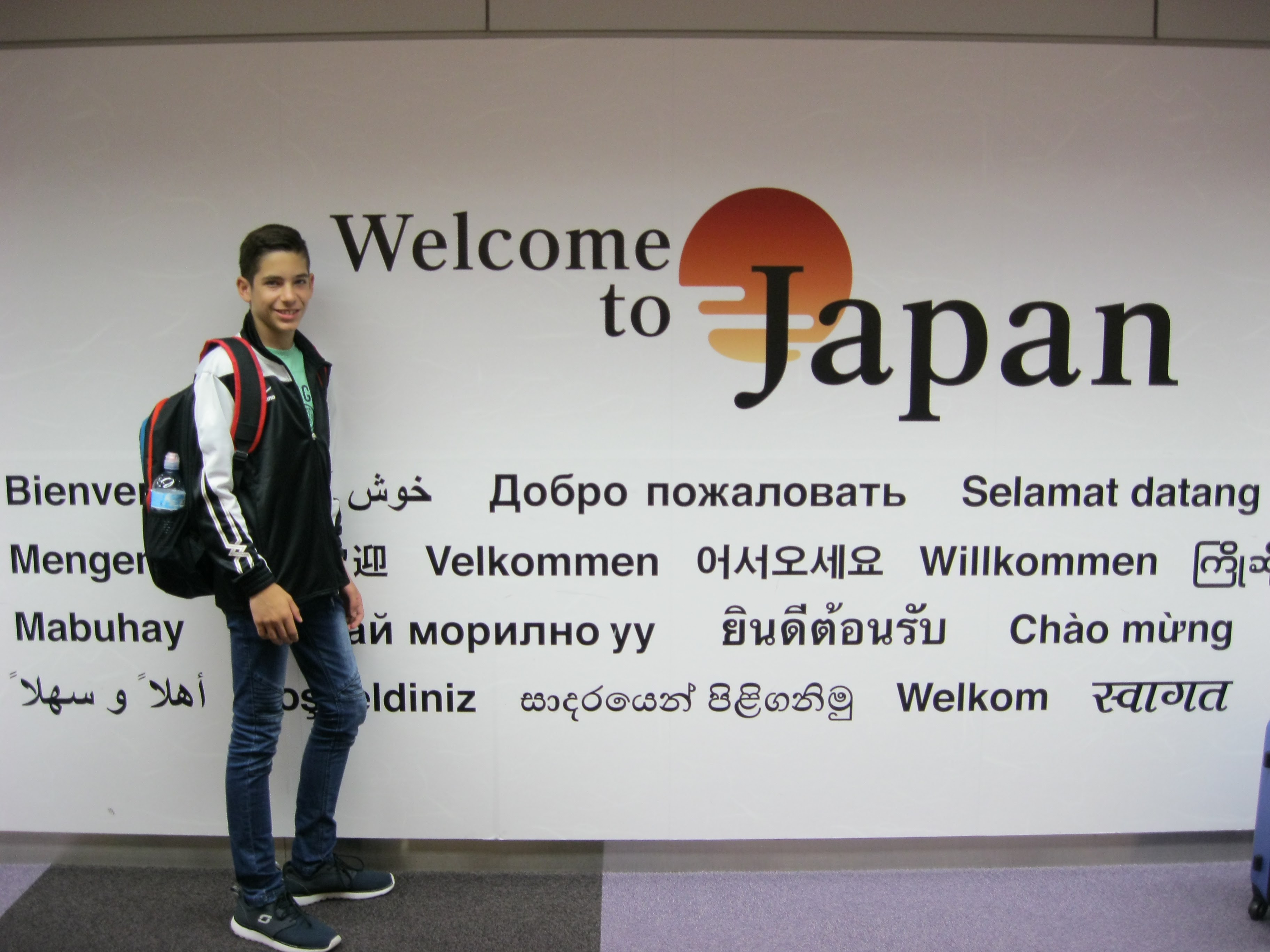 Dans la photo, je porte un pull noir et blanc, une chemise verte, un jean bleu et des chaussures bleues