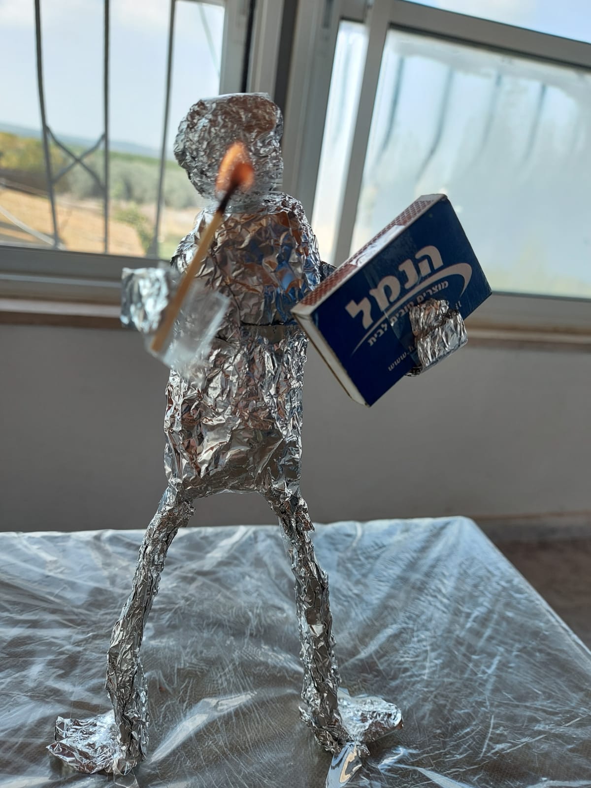 בתמונה הזאת הכנתי דמות מנייר כסף ושמתי ביד שלו גפרור